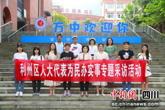 杨宇恒同媒体记者在学校门口合影。