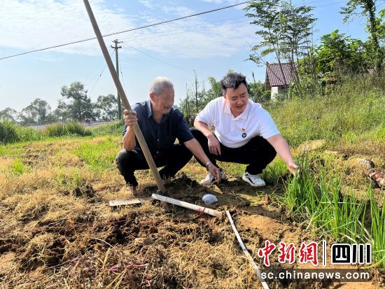 图为韦浩正在指导村民种植葱黄。内江市资中县烟草专卖局供图