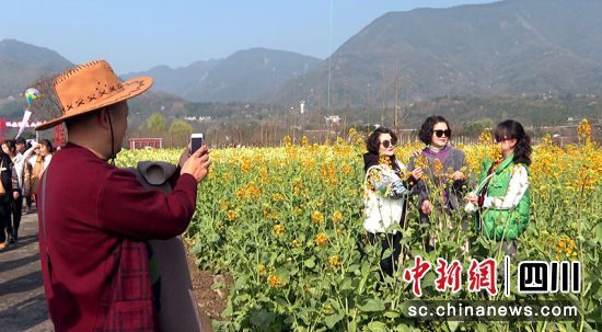 游客在油菜花田里拍照打卡。 绵竹市融媒体中心供图